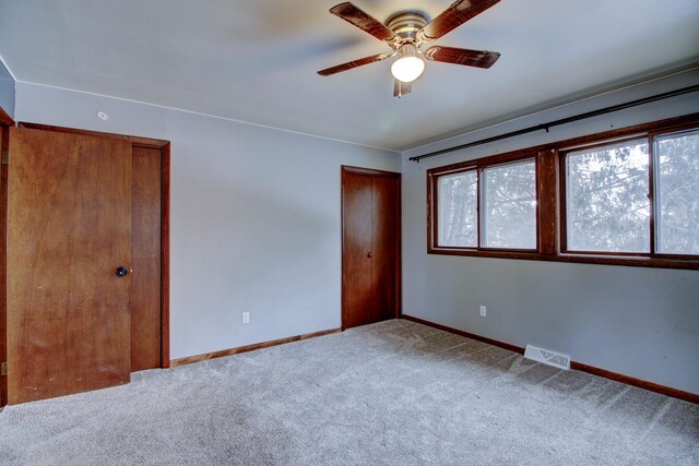 unfurnished bedroom with light colored carpet and ceiling fan