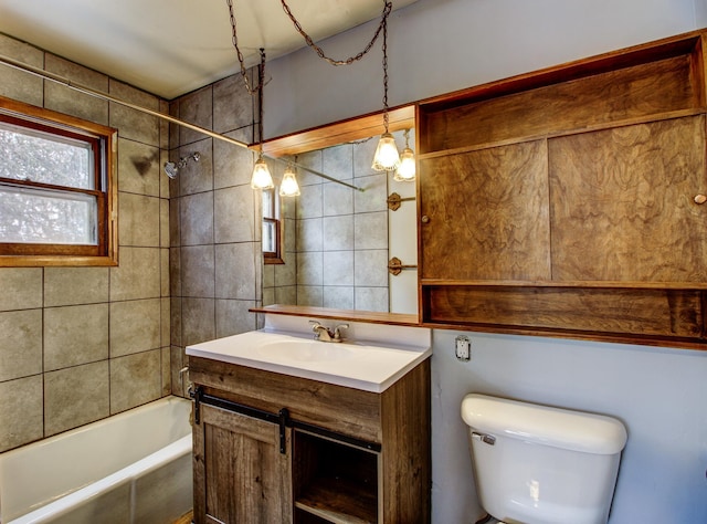 full bathroom featuring toilet, vanity, and tiled shower / bath combo