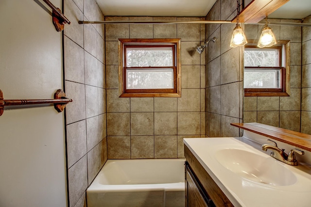 bathroom with tiled shower / bath combo and vanity