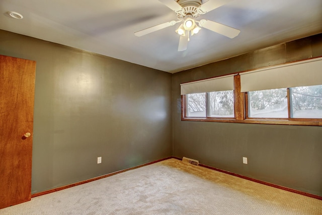 carpeted spare room with ceiling fan