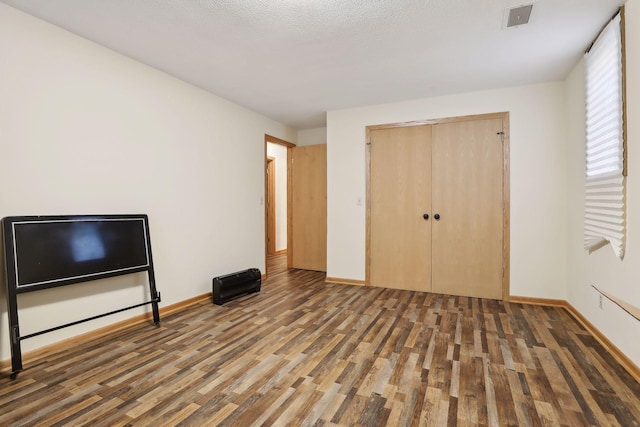 unfurnished bedroom featuring dark hardwood / wood-style floors and a closet