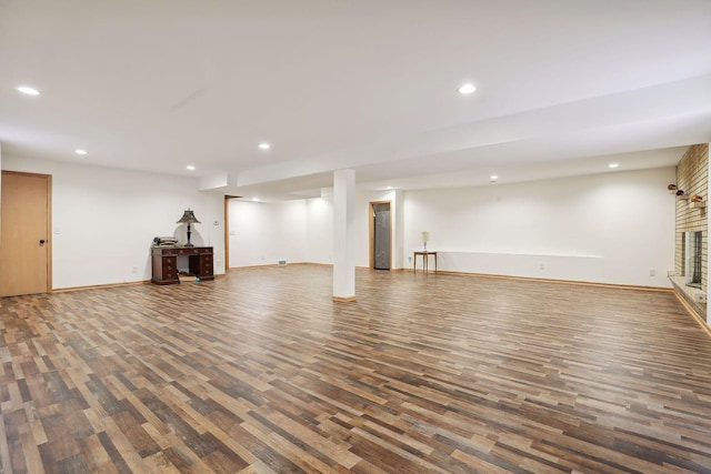 basement featuring a fireplace and dark wood-type flooring