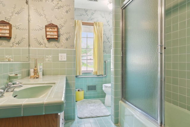 full bathroom featuring vanity, tile patterned flooring, toilet, enclosed tub / shower combo, and tile walls