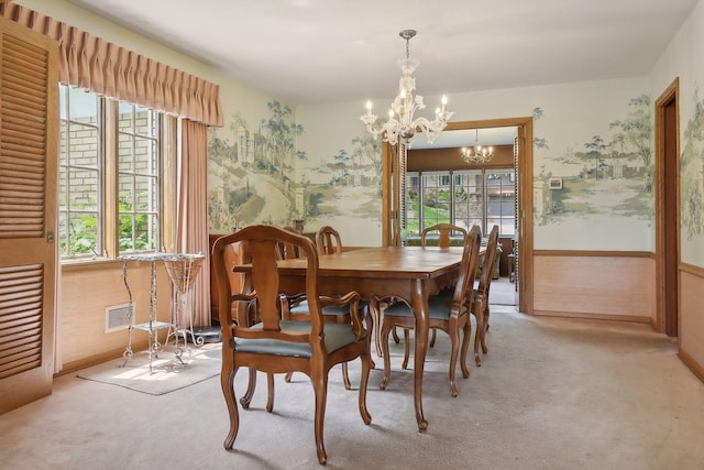 carpeted dining room with a chandelier