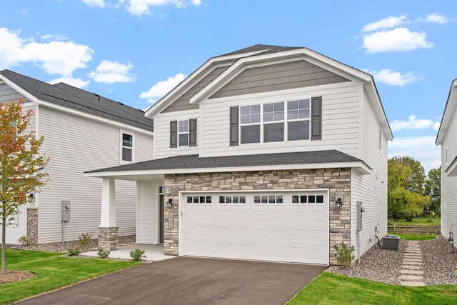 view of front of property featuring a garage and central AC