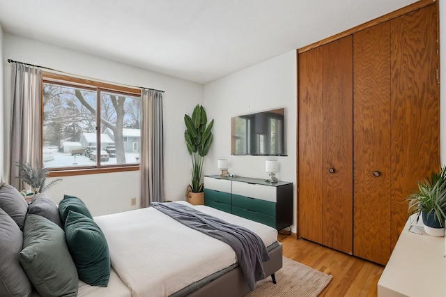 bedroom with light wood-type flooring and a closet