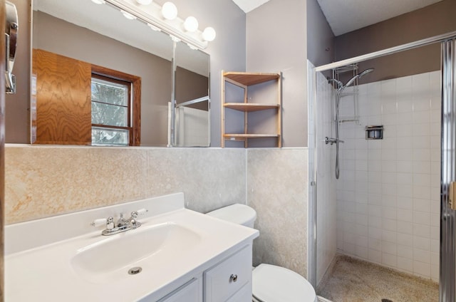 bathroom with toilet, vanity, and walk in shower