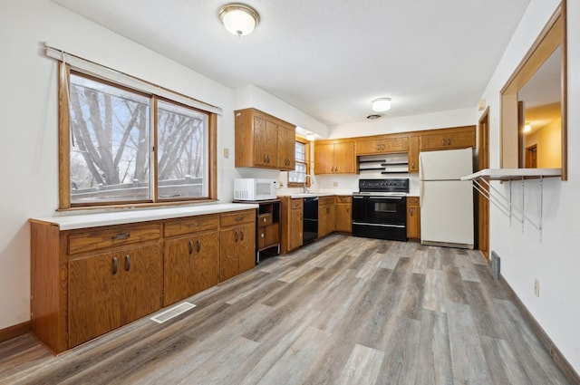 kitchen featuring black appliances, light hardwood / wood-style floors, and sink