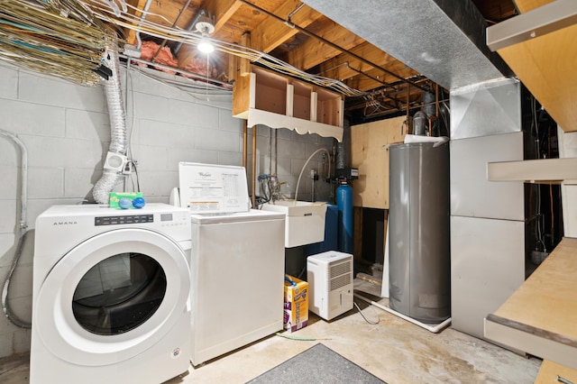 washroom featuring washing machine and clothes dryer, sink, and water heater