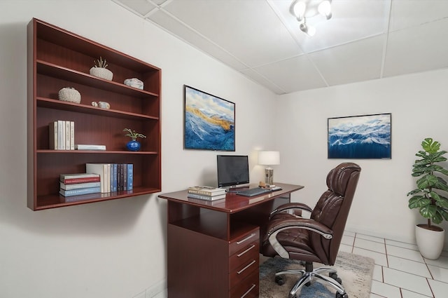 office area with a drop ceiling and light tile patterned floors