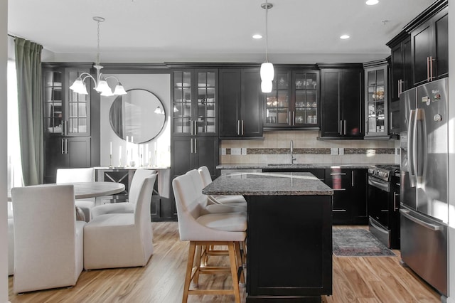 kitchen with appliances with stainless steel finishes, a center island, hanging light fixtures, and sink