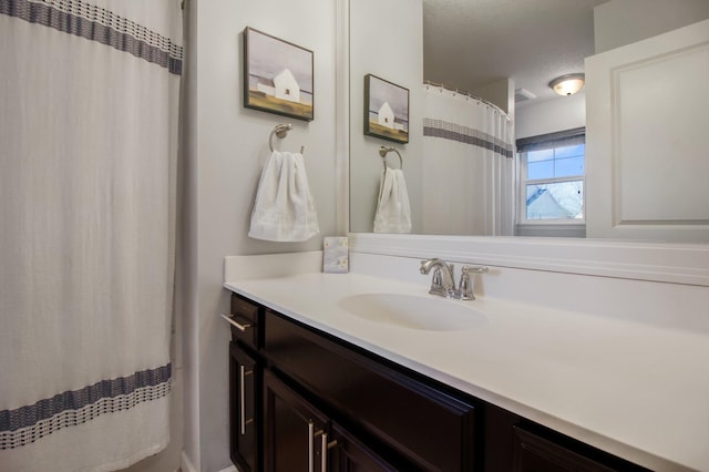 bathroom with a textured ceiling and vanity