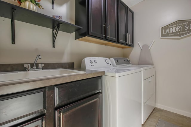 washroom with washing machine and clothes dryer, sink, and cabinets