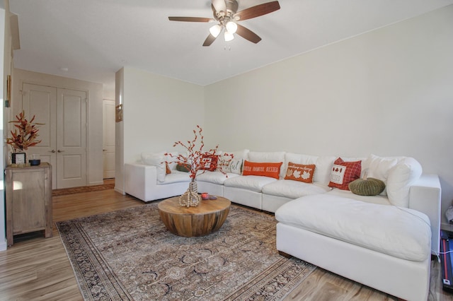 living room featuring light hardwood / wood-style flooring and ceiling fan