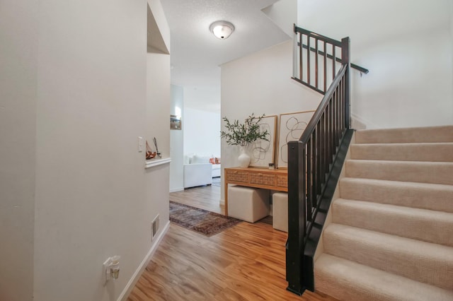 stairway featuring wood-type flooring