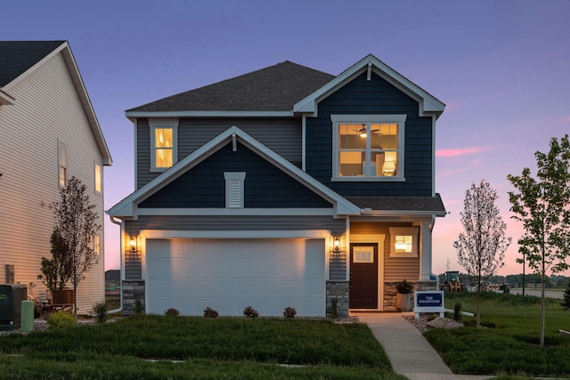 craftsman inspired home featuring a garage, central AC unit, and a lawn