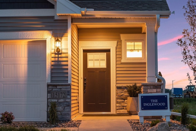 exterior entry at dusk with a garage