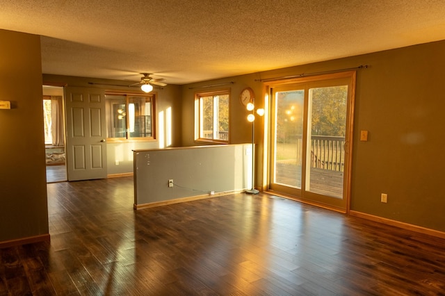 spare room featuring dark hardwood / wood-style flooring, a textured ceiling, and ceiling fan