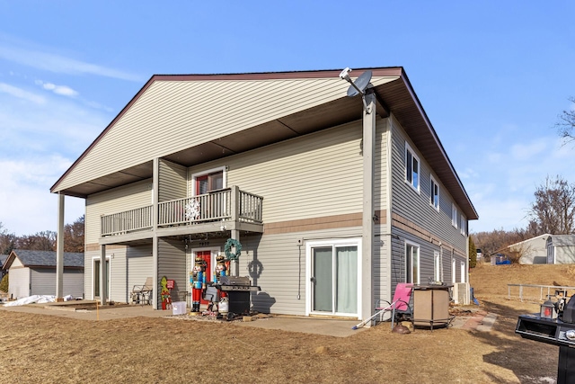 rear view of property featuring a balcony