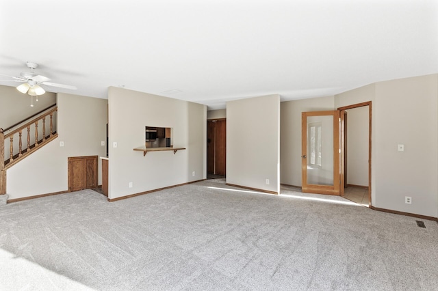 unfurnished living room with light carpet and ceiling fan