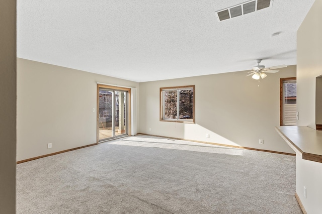 unfurnished living room featuring ceiling fan, light colored carpet, and a textured ceiling