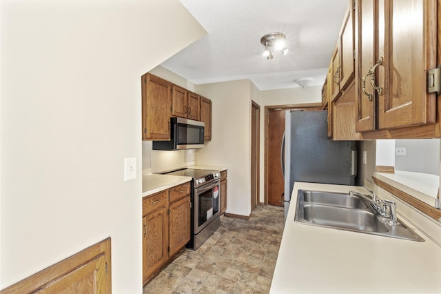 kitchen with sink, a textured ceiling, and appliances with stainless steel finishes