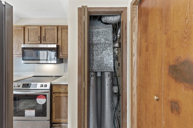 kitchen with appliances with stainless steel finishes and a textured ceiling