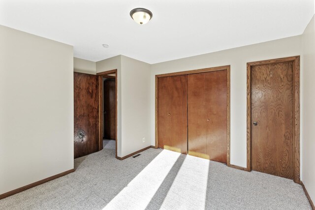 unfurnished bedroom featuring light carpet