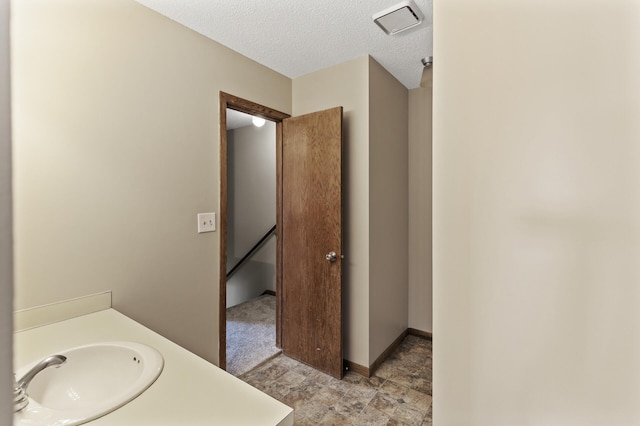 bathroom with vanity and a textured ceiling