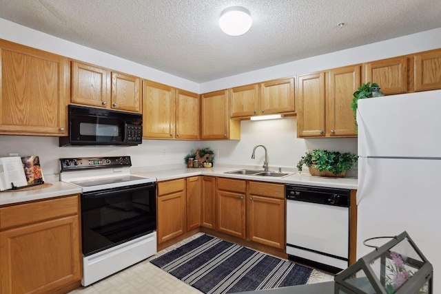 kitchen with a textured ceiling, white appliances, and sink