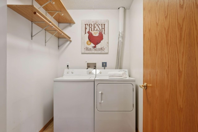 washroom featuring washing machine and clothes dryer and a textured ceiling