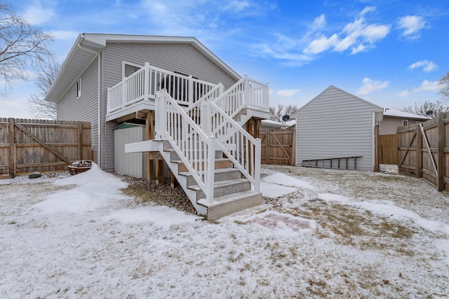 snow covered house featuring a wooden deck