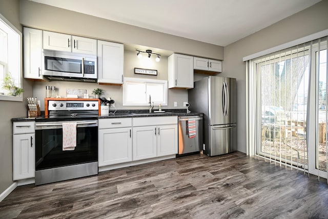 kitchen featuring white cabinetry, sink, dark wood-type flooring, and appliances with stainless steel finishes