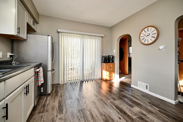 kitchen featuring white cabinetry, sink, dark wood-type flooring, and stainless steel dishwasher