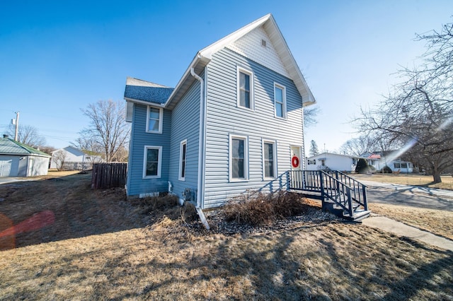 view of side of home featuring fence