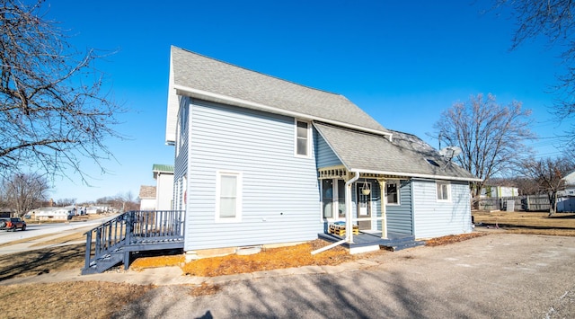 back of property featuring covered porch