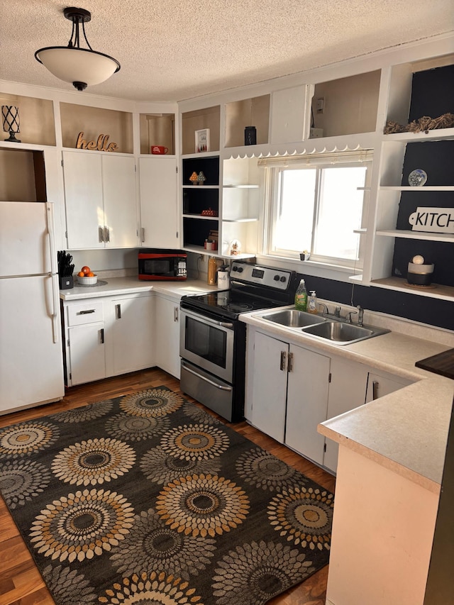 kitchen featuring sink, white cabinetry, hanging light fixtures, stainless steel electric range oven, and white fridge