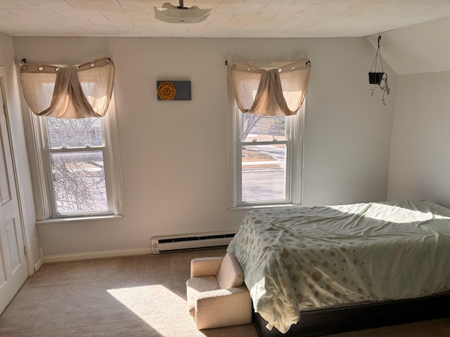 carpeted bedroom featuring a baseboard heating unit and vaulted ceiling