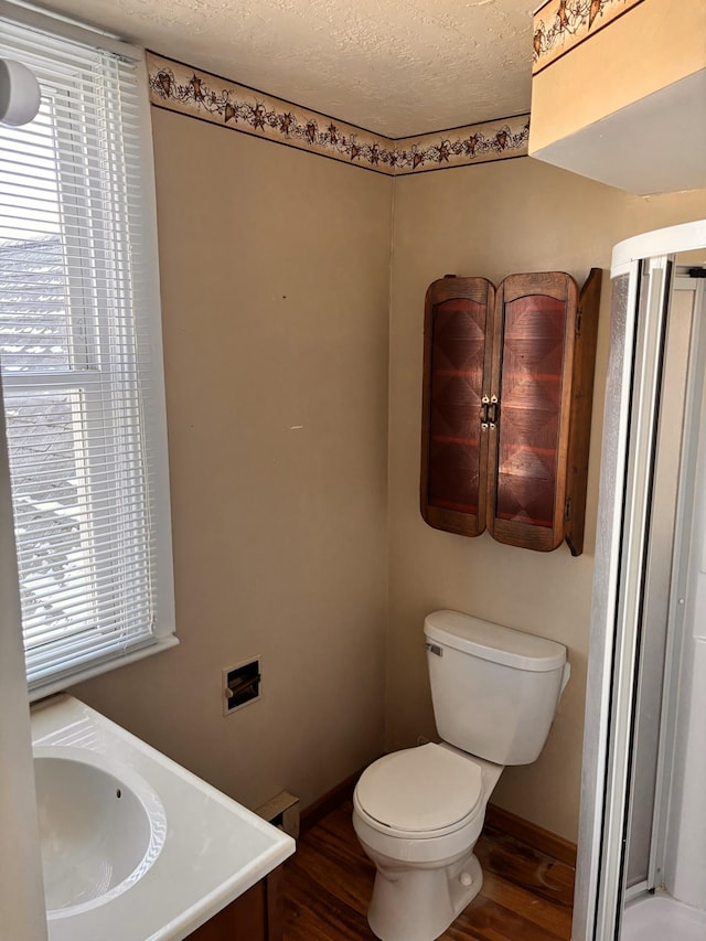 bathroom with vanity, toilet, hardwood / wood-style floors, and a textured ceiling