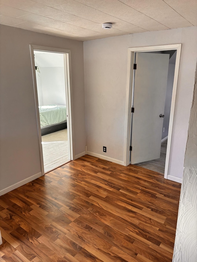 empty room with baseboards and wood finished floors