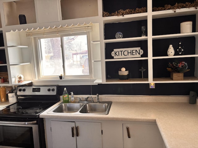 kitchen featuring light countertops, a sink, electric range, and open shelves