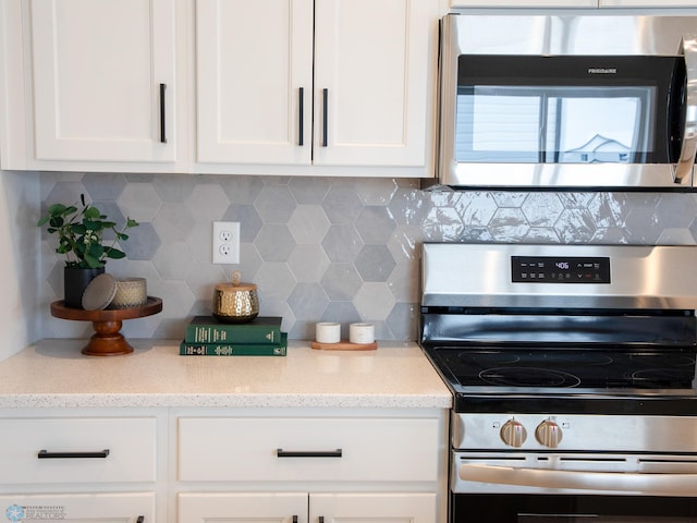 kitchen featuring white cabinets, stainless steel appliances, and decorative backsplash