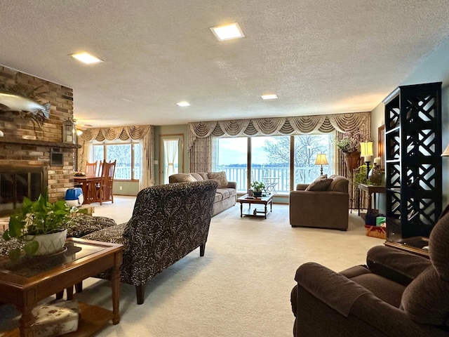 living room featuring a fireplace, a textured ceiling, and carpet flooring