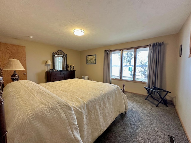 bedroom featuring a textured ceiling and carpet floors