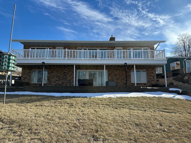 rear view of property with a wooden deck and a yard