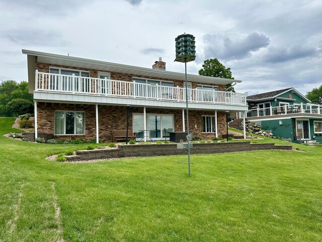 1606 Shore Dr, Worthington, MN 56187 - back of property featuring a chimney, a yard, and brick siding
