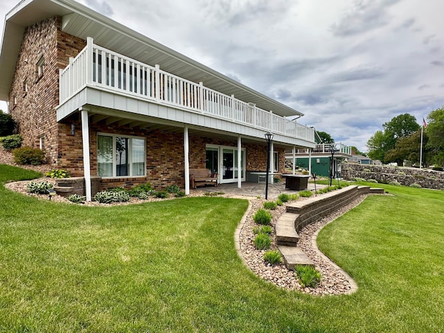 1606 Shore Dr, Worthington, MN 56187 - back of house featuring brick siding, a lawn, a deck, and a patio