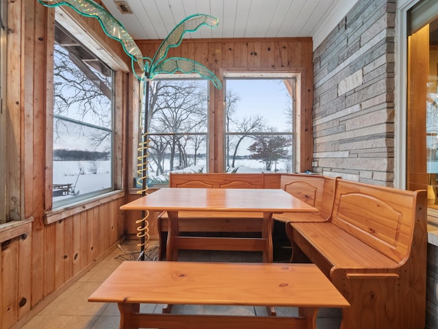 dining room with wood walls, wood ceiling, breakfast area, and a wealth of natural light