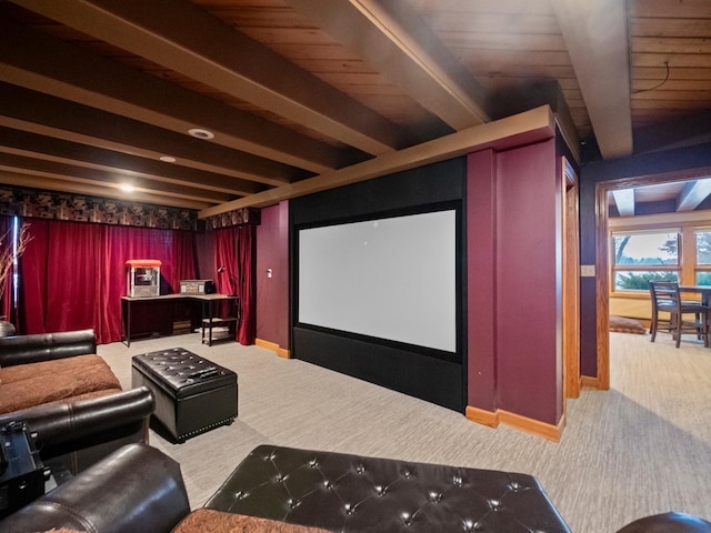 carpeted home theater with beam ceiling and baseboards