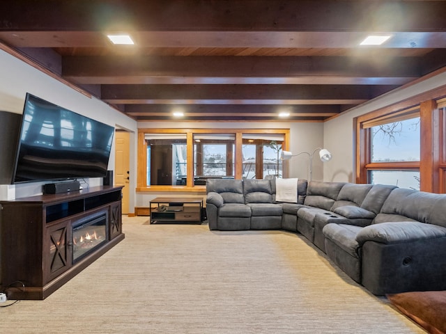 carpeted living room with beamed ceiling, a water view, and a healthy amount of sunlight